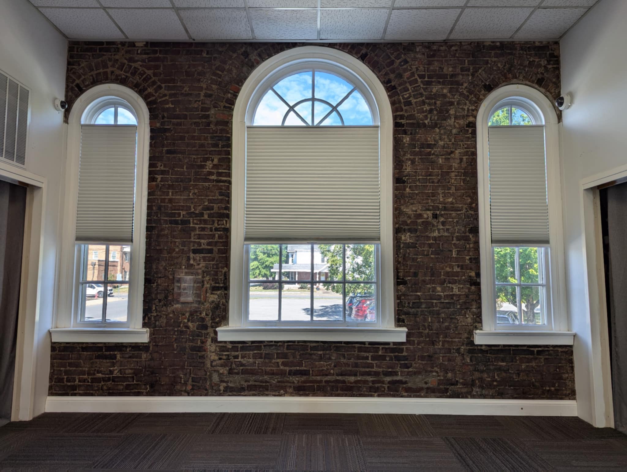 Photo of three arched windows from inside the Auditorium room