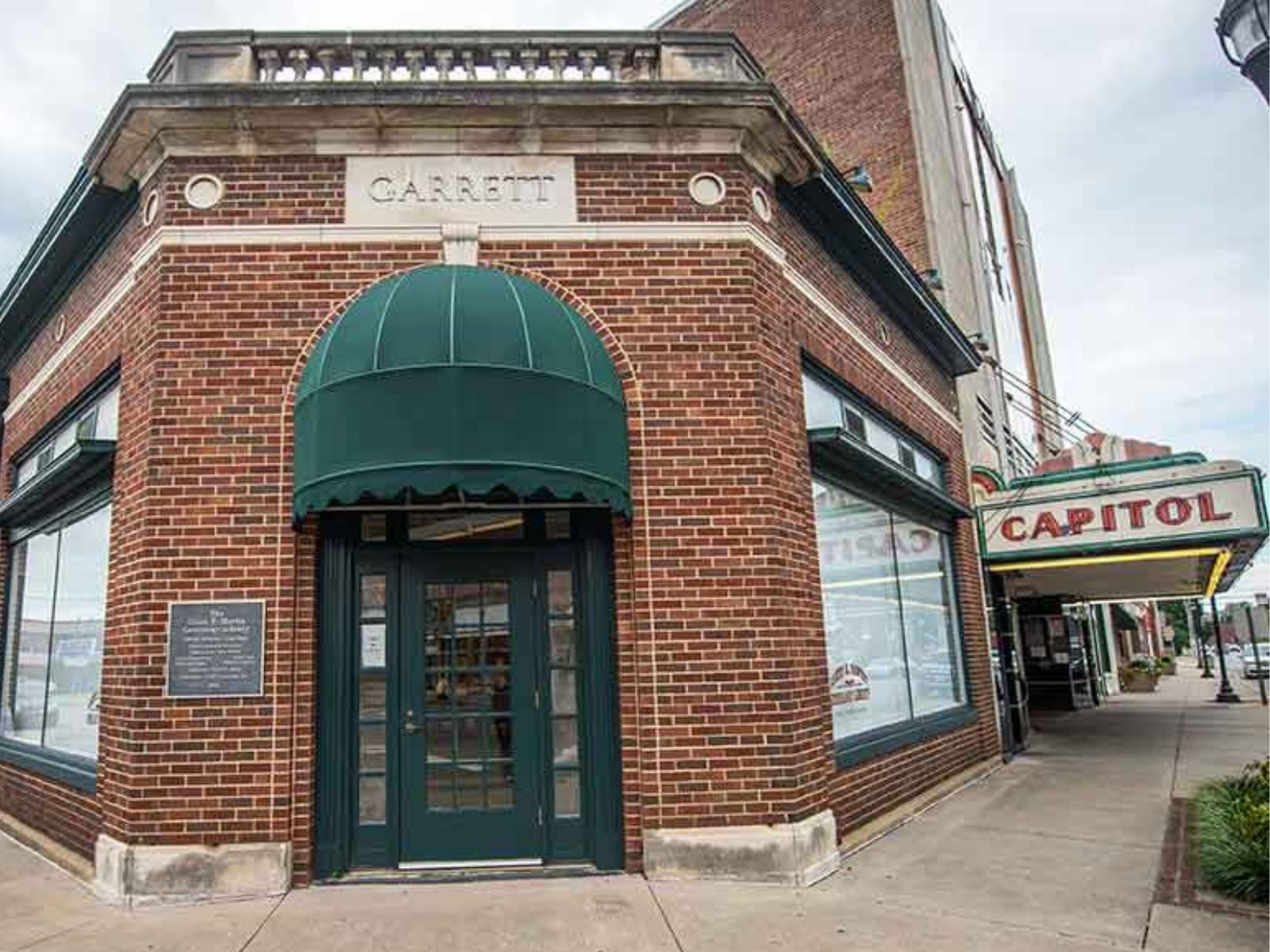 Genealogy Center entrance: a green wood door with glass panes an covered arch set into corner of a brick building with "GARRETT" inscribed above