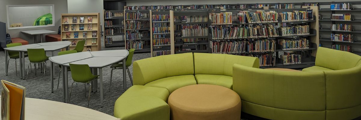 Junior young adults area at the library featuring bookshelves, tables, and modular rounded green seating